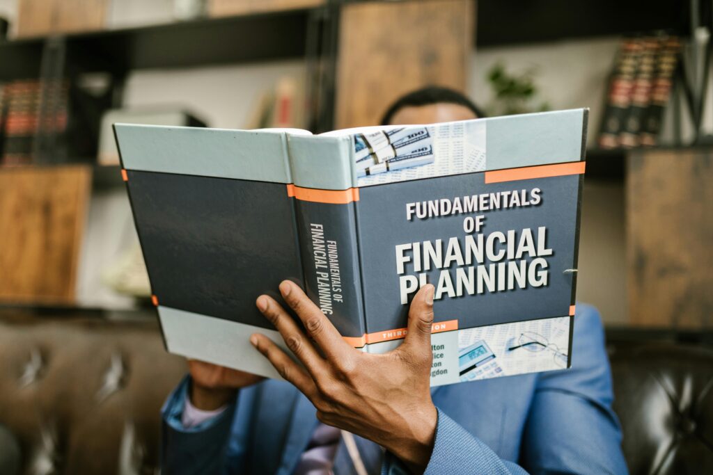 pexels-photo-7821487-7821487 Person Reading a Book About Fundamentals of Financial Planning